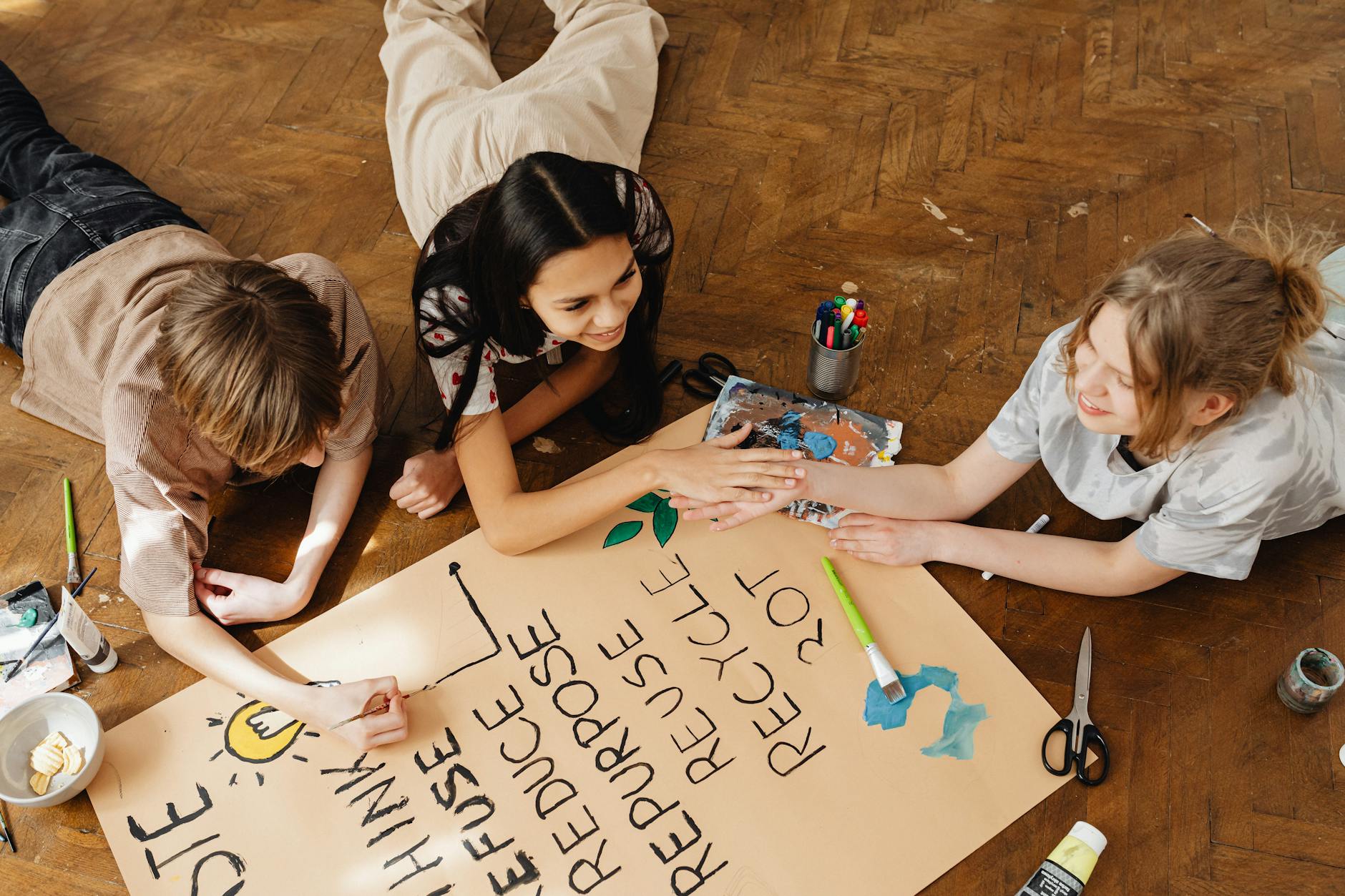 friends painting on brown paper